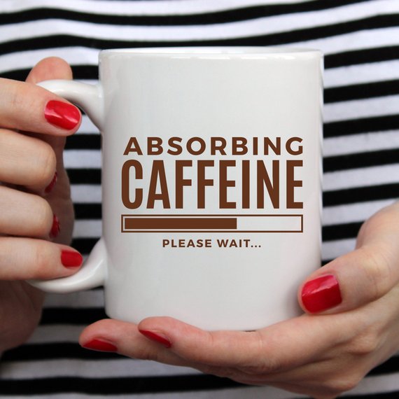 A humorous coffee mug with the phrase 'Absorbing Caffeine Please Wait', showcasing a fun design perfect for Mother's Day gifts.