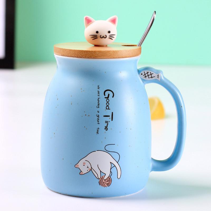 A colorful ceramic coffee mug featuring an adorable cat cartoon design, available in pink, yellow, and blue.