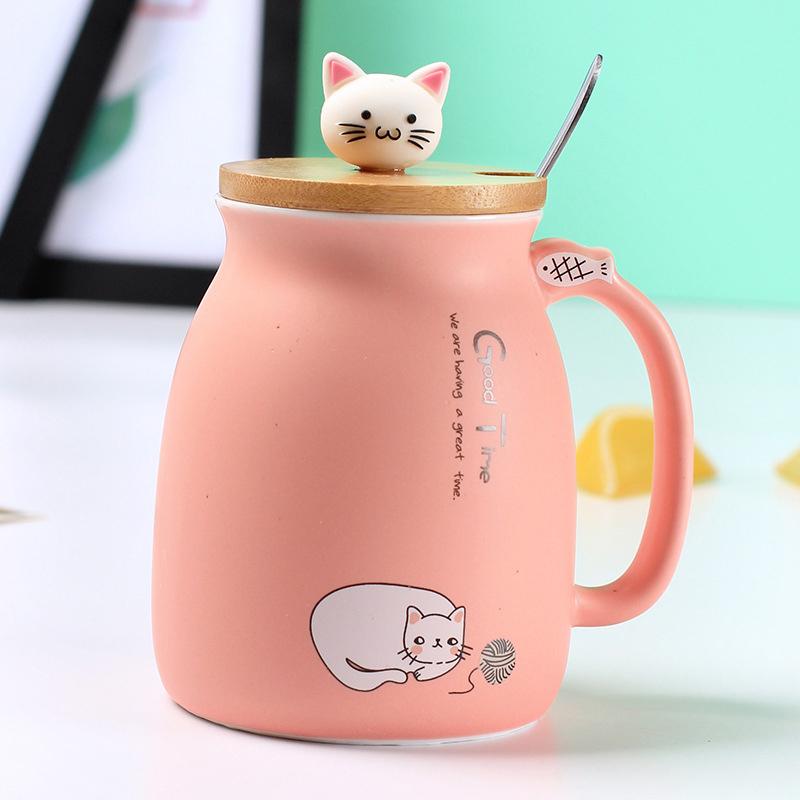 A colorful ceramic coffee mug featuring an adorable cat cartoon design, available in pink, yellow, and blue.