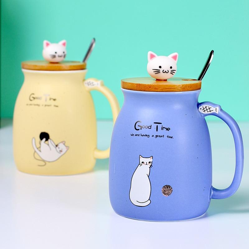 A colorful ceramic coffee mug featuring an adorable cat cartoon design, available in pink, yellow, and blue.