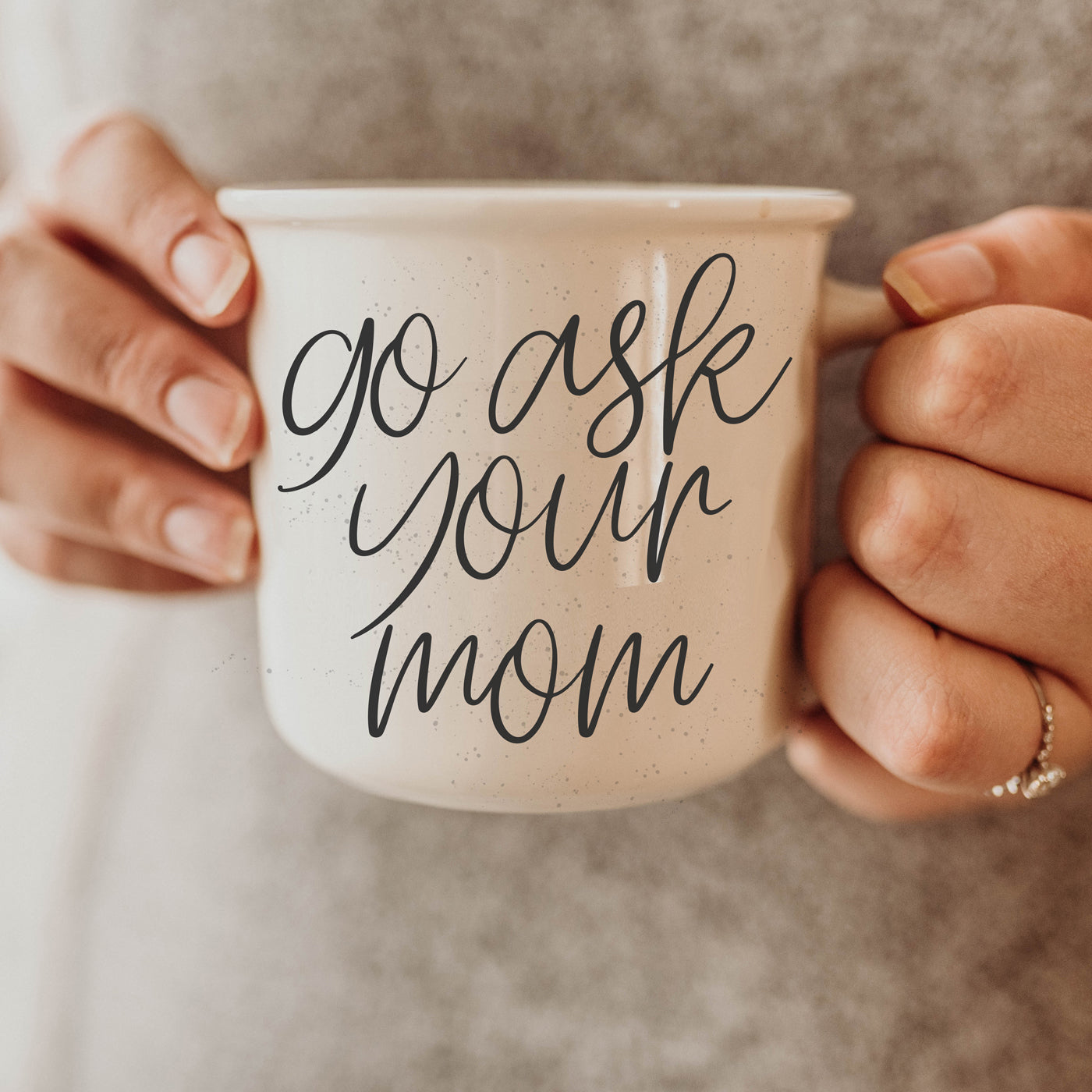 A stylish 14.5oz ceramic coffee mug with a white sesame glaze, featuring the phrase 'Ask Your Mom' in bold black lettering on both sides.