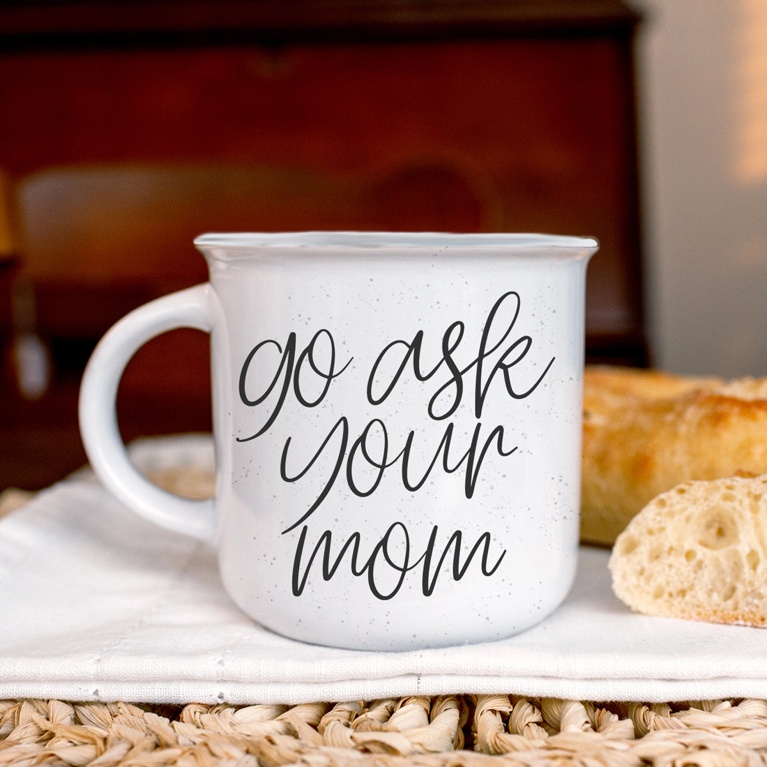 A stylish 14.5oz ceramic coffee mug with a white sesame glaze, featuring the phrase 'Ask Your Mom' in bold black lettering on both sides.