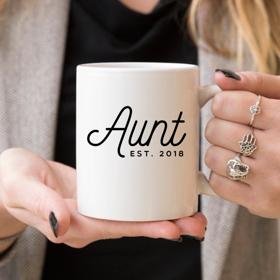 A white ceramic mug with 'Aunt Est 2018' printed on both sides, showcasing a vibrant design.