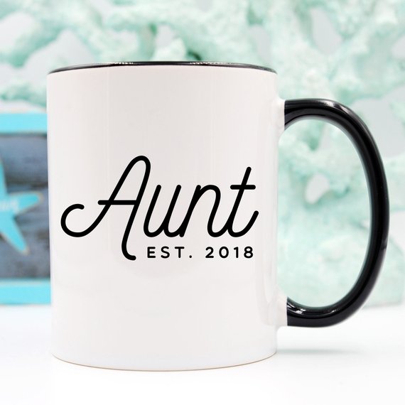 A white ceramic mug with 'Aunt Est 2018' printed on both sides, showcasing a vibrant design.