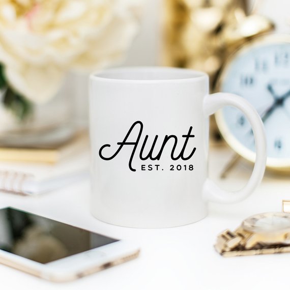 A white ceramic mug with 'Aunt Est 2018' printed on both sides, showcasing a vibrant design.