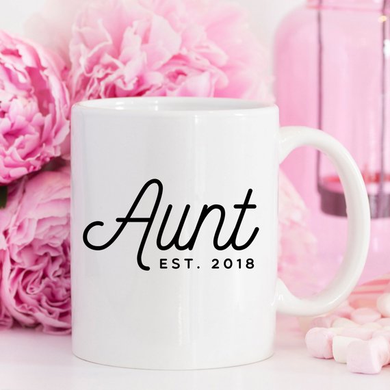 A white ceramic mug with 'Aunt Est 2018' printed on both sides, showcasing a vibrant design.