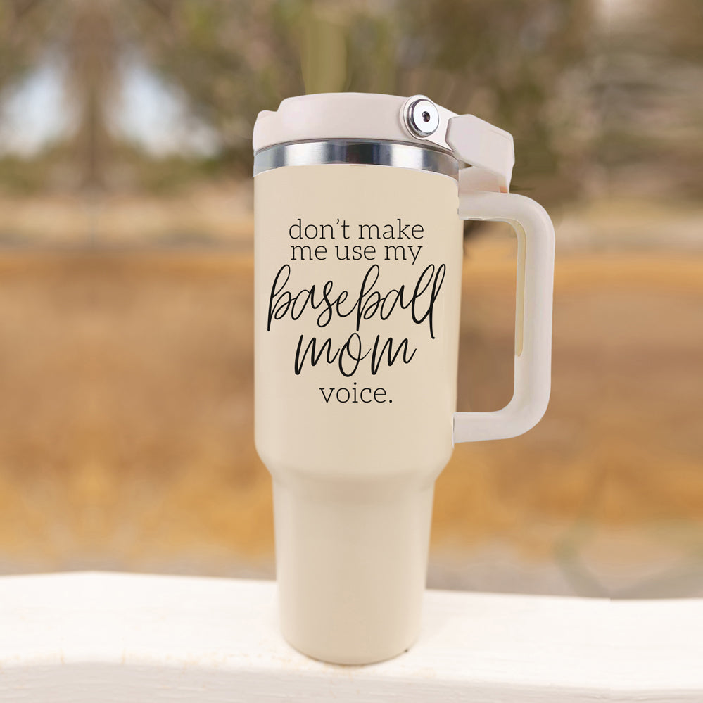 A stylish cream tumbler with a stainless steel interior, featuring the phrase 'Don't Make Me Use My Baseball Mom Voice' in bold black graphic.