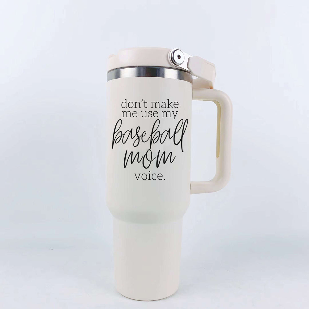 A stylish cream tumbler with a stainless steel interior, featuring the phrase 'Don't Make Me Use My Baseball Mom Voice' in bold black graphic.