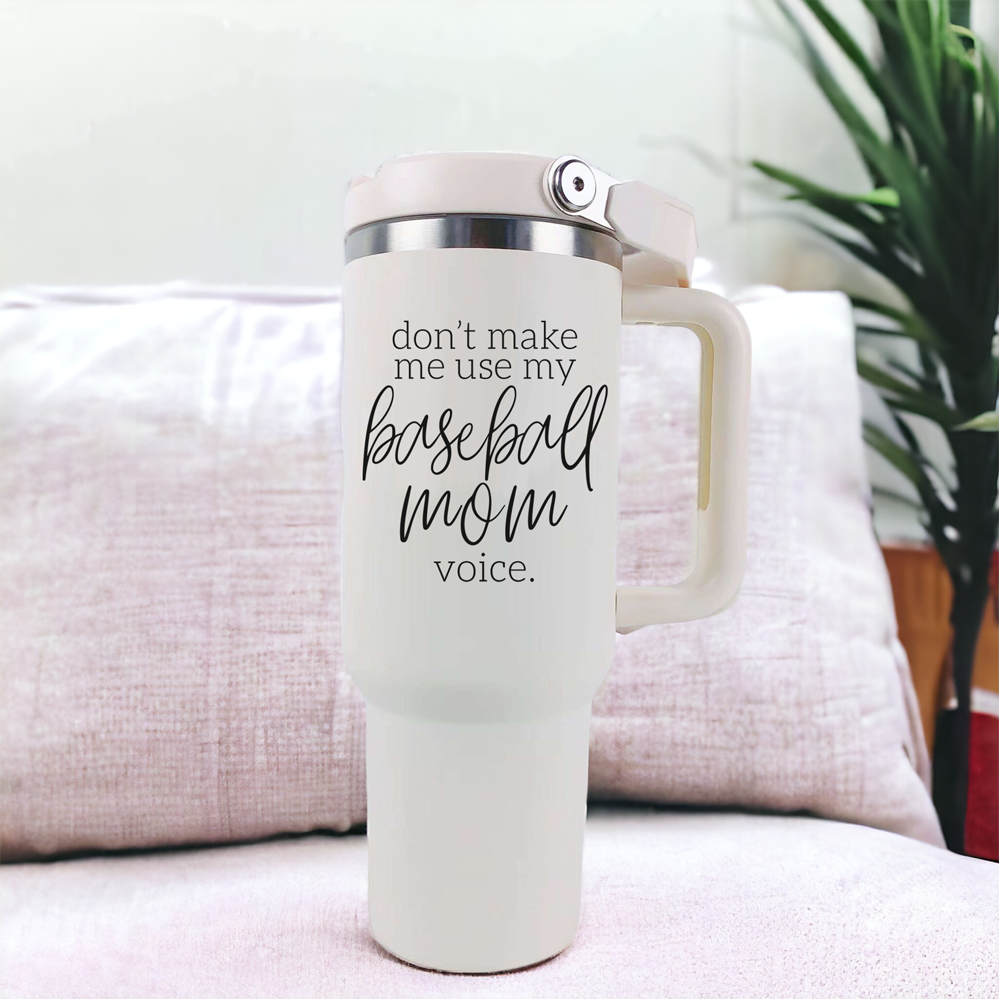 A stylish cream tumbler with a stainless steel interior, featuring the phrase 'Don't Make Me Use My Baseball Mom Voice' in bold black graphic.