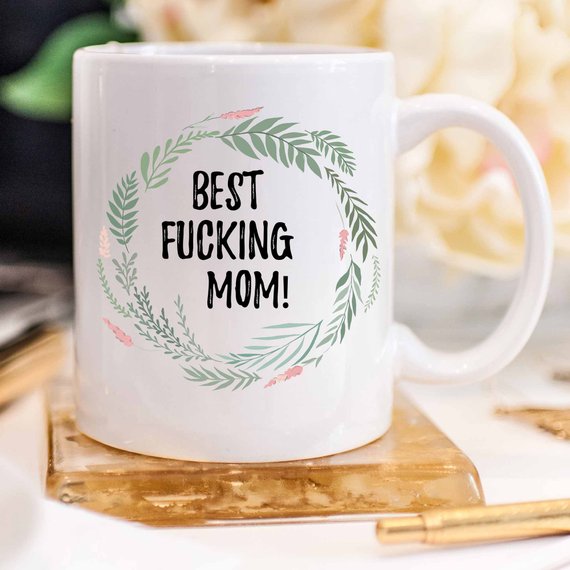 A white ceramic mug with 'Best Fucking Mom' printed on both sides, showcasing a vibrant design.