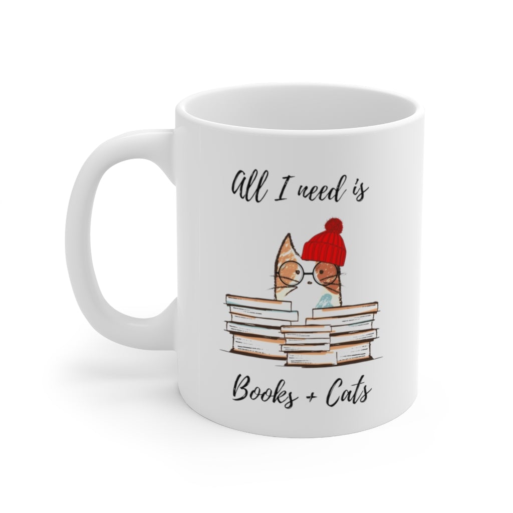 A white ceramic mug with the phrase 'All I Need is Books & Cats' printed on it, perfect for book lovers.