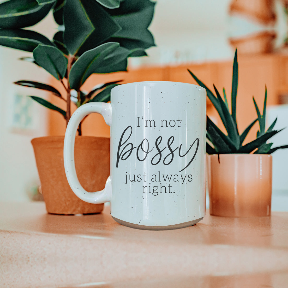 A stylish off-white ceramic coffee mug with dark speckles, featuring the bold text 'I'm Not Bossy, Just Always Right' on both sides.