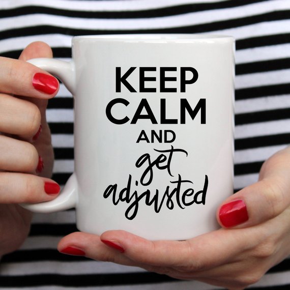 A humorous coffee mug featuring the phrase 'Keep Calm And Get Adjusted', designed for chiropractors, made of high-quality ceramic.