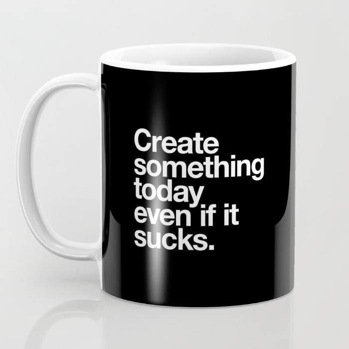 A 15-ounce ceramic coffee mug featuring the phrase 'Create Something Today Even If It Sucks' with a wrap-around art design and a large handle.