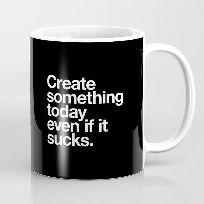 A 15-ounce ceramic coffee mug featuring the phrase 'Create Something Today Even If It Sucks' with a wrap-around art design and a large handle.