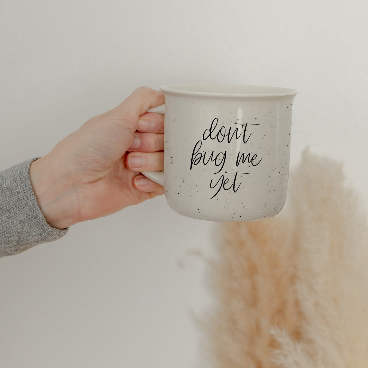 Don't Bug Me Yet 14.5oz ceramic coffee mug with double-sided design, featuring light ivory color and black lettering.