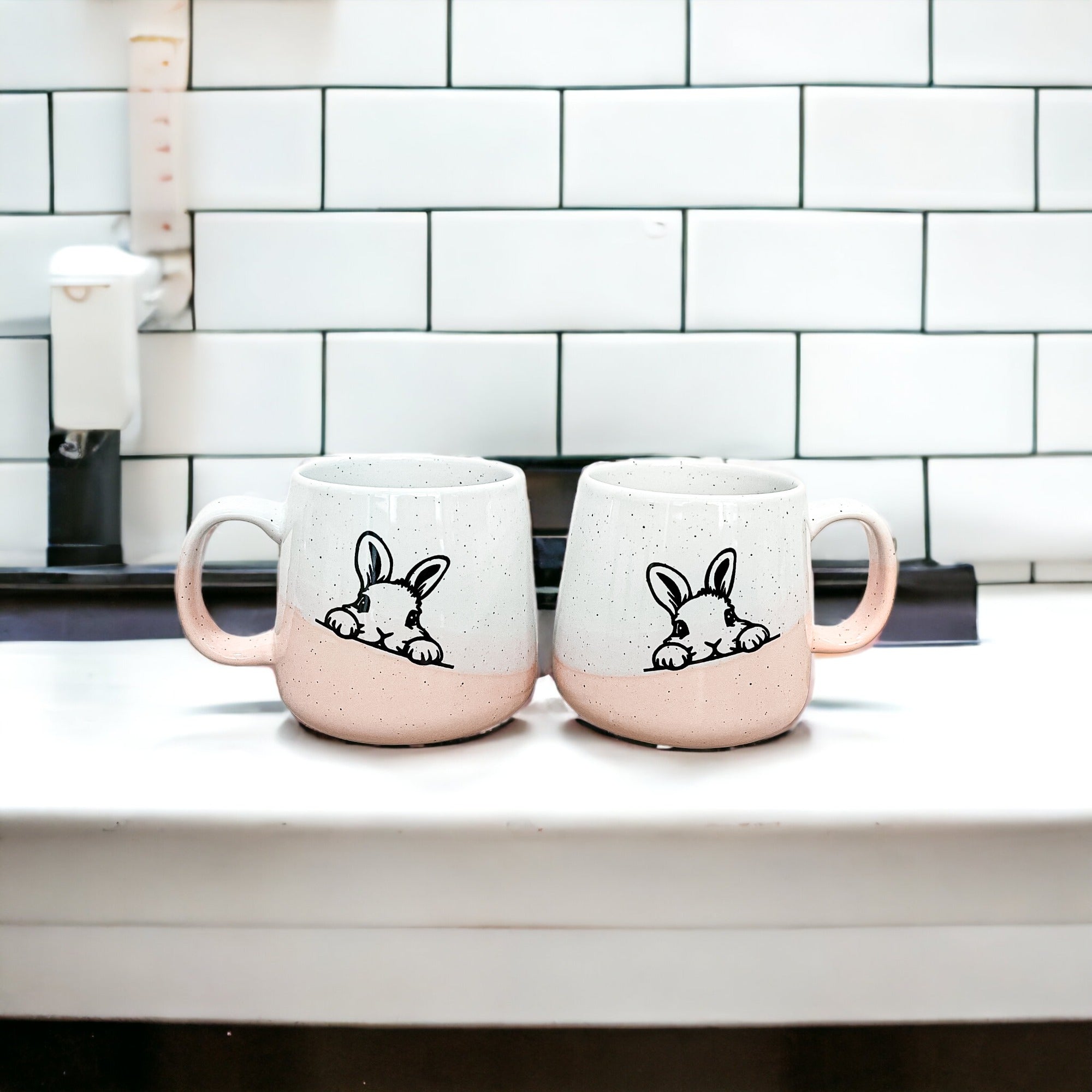 Handcrafted ceramic mug featuring a bunny silhouette and pastel pink base, perfect for coffee or tea.