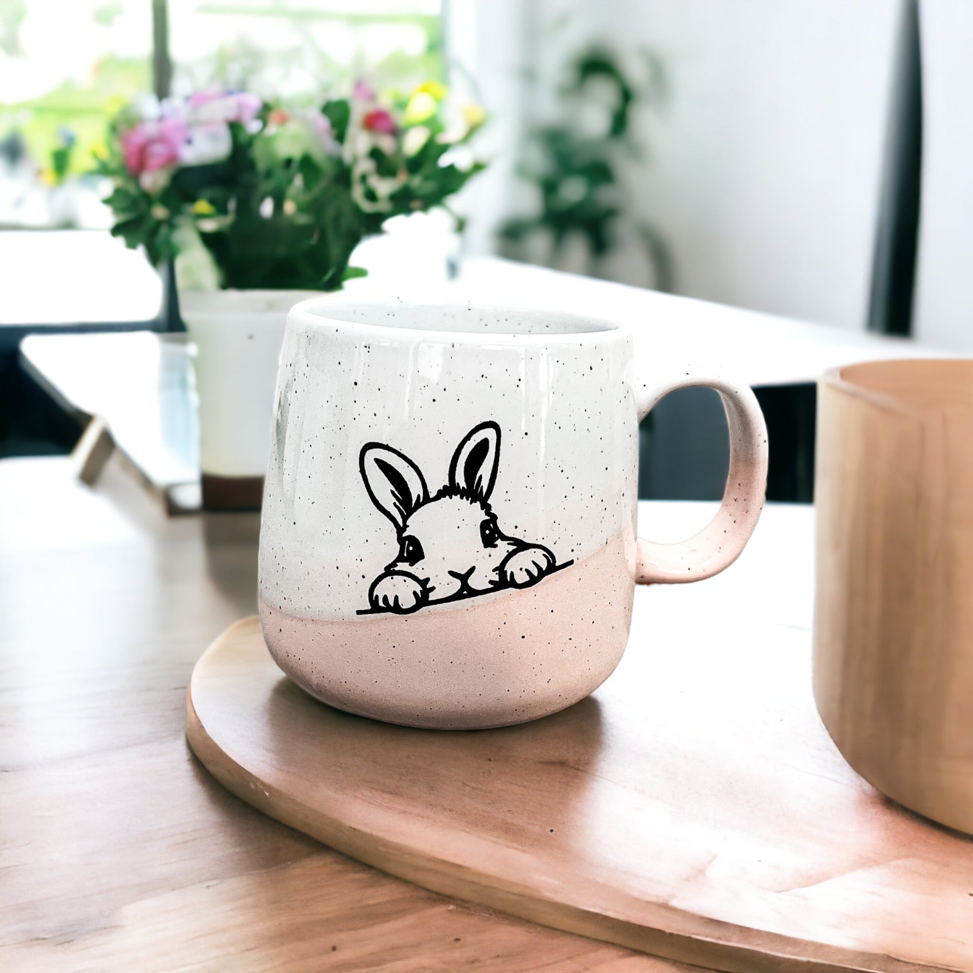 Handcrafted ceramic mug featuring a bunny silhouette and pastel pink base, perfect for coffee or tea.