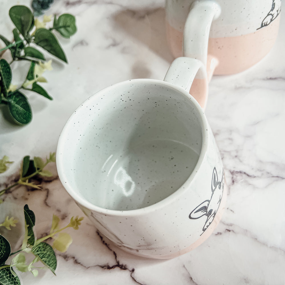 Handcrafted ceramic mug featuring a bunny silhouette and pastel pink base, perfect for coffee or tea.