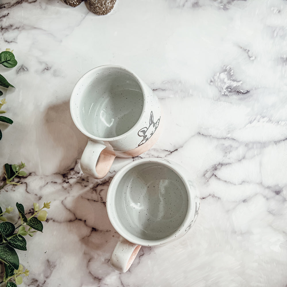 Handcrafted ceramic mug featuring a bunny silhouette and pastel pink base, perfect for coffee or tea.