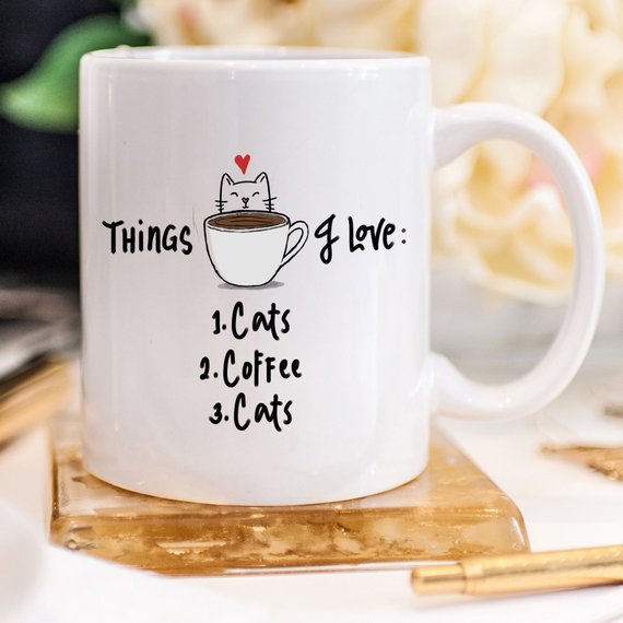 A humorous coffee mug featuring the text 'Things I Love: 1. Cats 2. Coffee 3. Cats', designed for cat lovers.