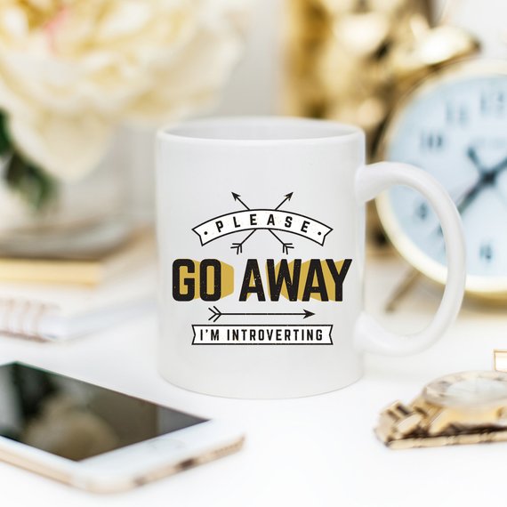 A humorous coffee mug featuring the phrase 'Please Go Away I'm Introverting', made of high-quality ceramic, perfect for introverts.