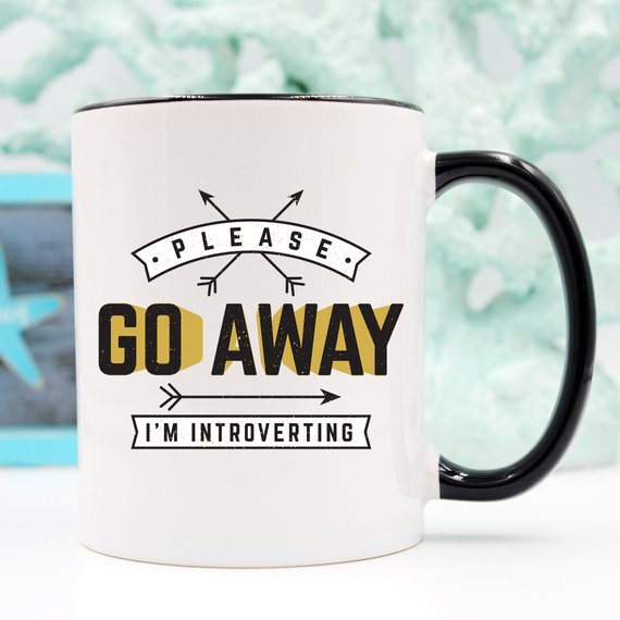 A humorous coffee mug featuring the phrase 'Please Go Away I'm Introverting', made of high-quality ceramic, perfect for introverts.