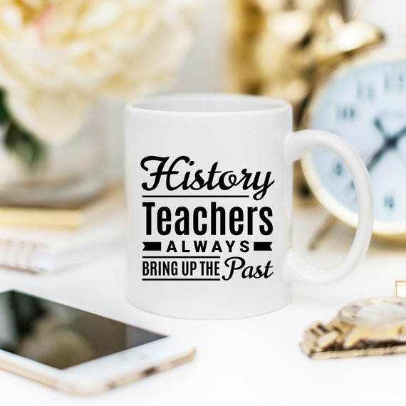 A humorous coffee mug featuring the phrase 'History Teachers Always Bring Up The Past', crafted from high-quality ceramic, ideal for teachers and coffee lovers.