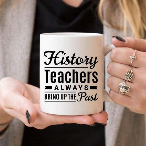 A humorous coffee mug featuring the phrase 'History Teachers Always Bring Up The Past', crafted from high-quality ceramic, ideal for teachers and coffee lovers.