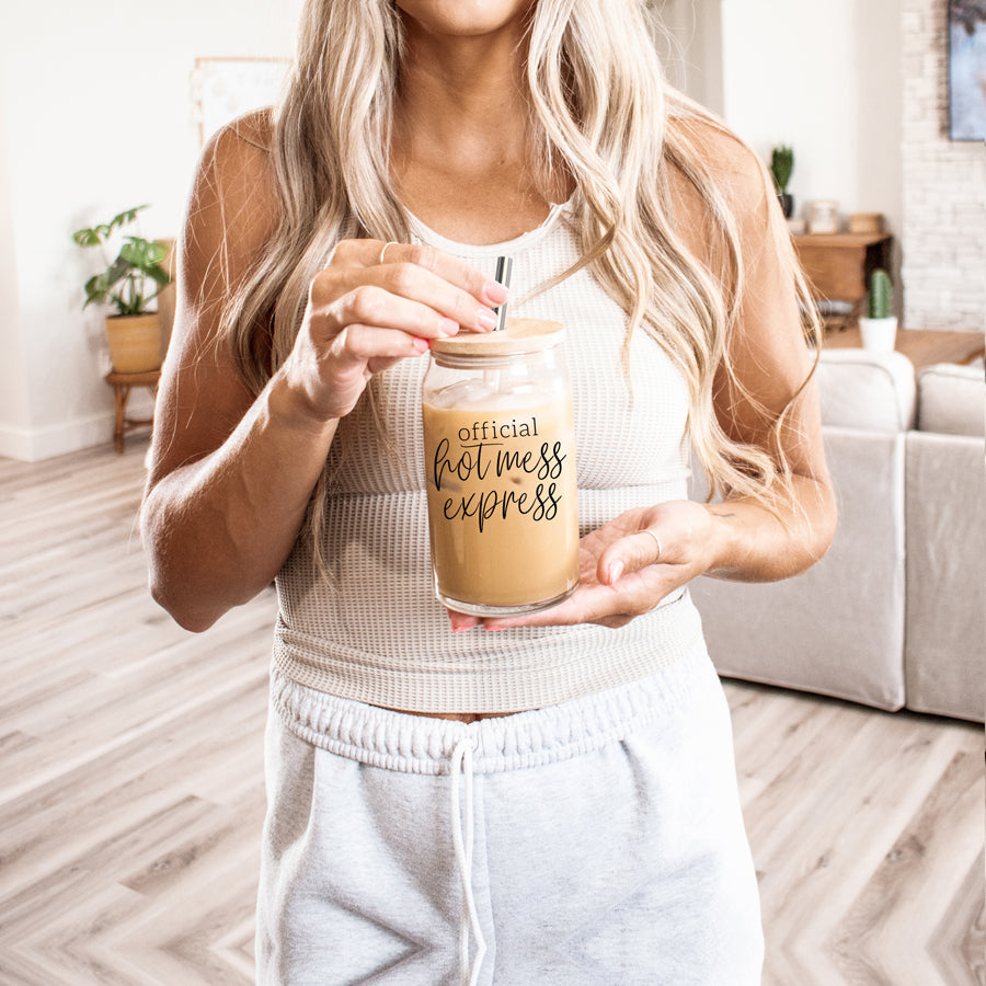 Hot Mess glass drinking cup with bamboo lid and stainless steel straws, showcasing a modern design and black graphic.