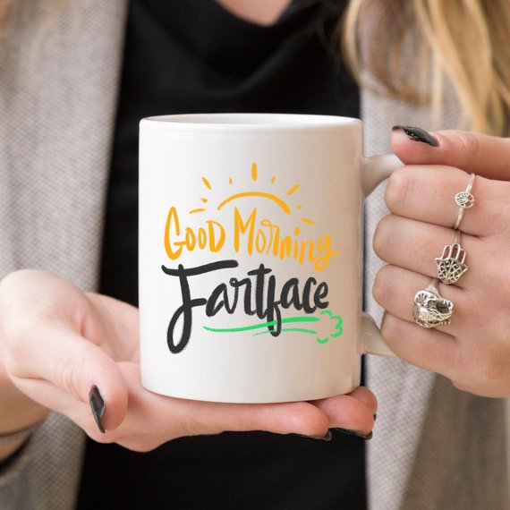 A humorous 'Good Morning Fartface' coffee mug featuring a playful design, perfect for gifting to husbands.