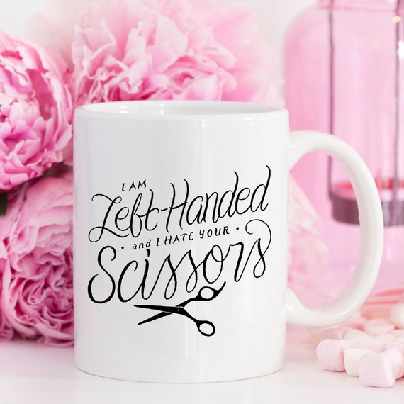 A humorous coffee mug featuring the phrase 'I Am Left-Handed And I Hate Your Scissors', designed for left-handed users.