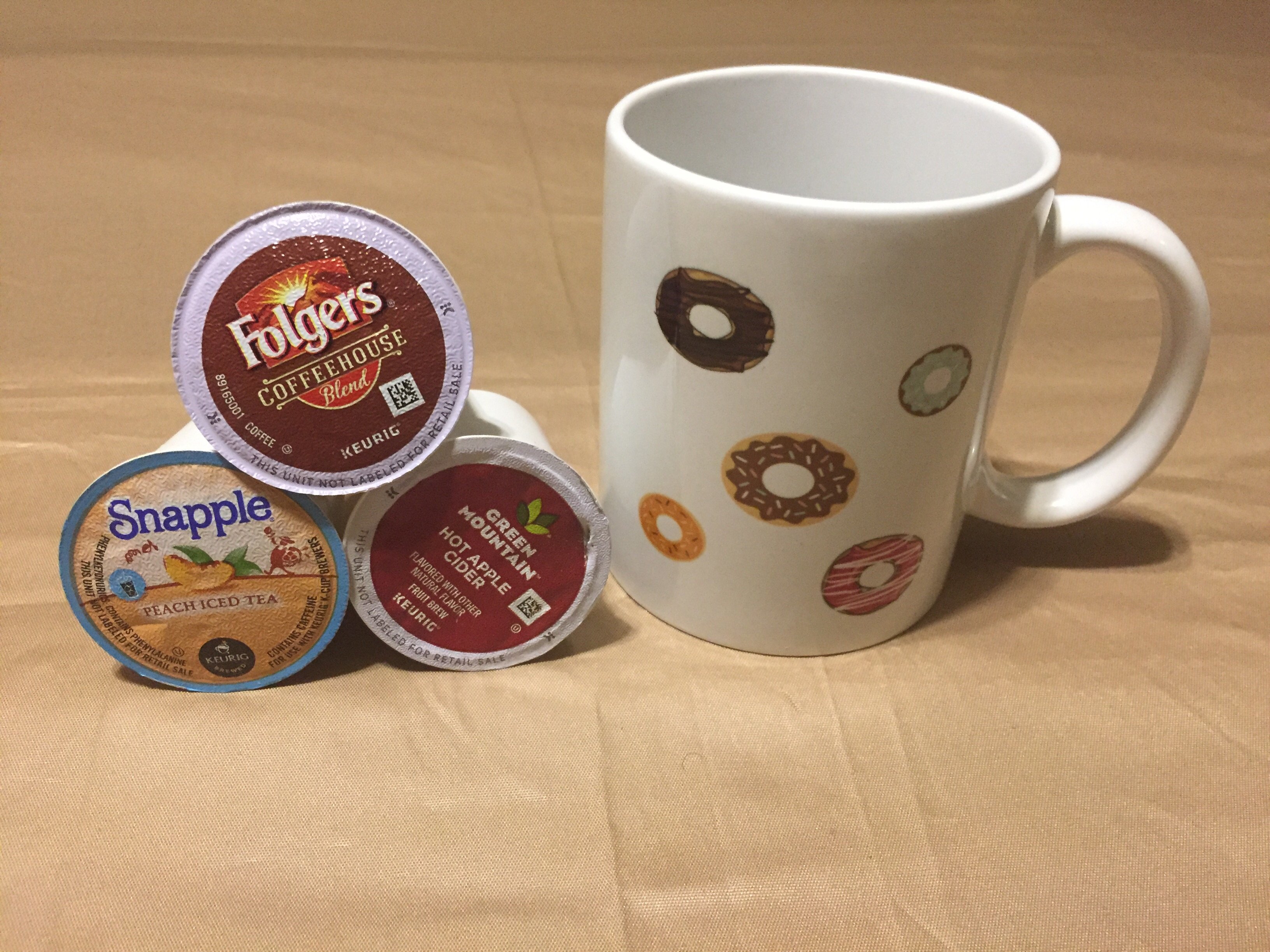 A glossy white ceramic mug with the phrase 'I Can Eat All The Doughnuts' printed on it, perfect for coffee or tea.