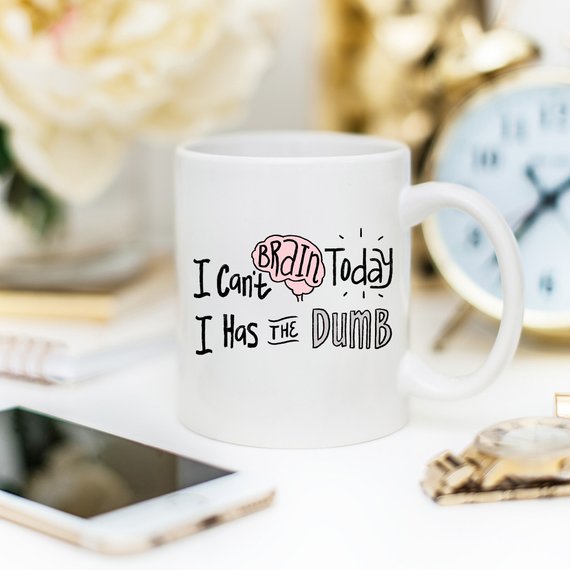 A humorous coffee mug with the phrase 'I Can't Brain Today, I Has The Dumb' printed on it, showcasing a fun design perfect for coffee lovers.