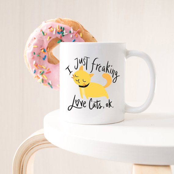 A humorous coffee mug featuring the phrase 'I Just Freaking Love Cats OK', designed for cat lovers, made from high-quality ceramic.