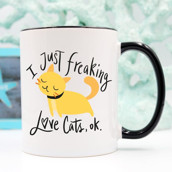 A humorous coffee mug featuring the phrase 'I Just Freaking Love Cats OK', designed for cat lovers, made from high-quality ceramic.