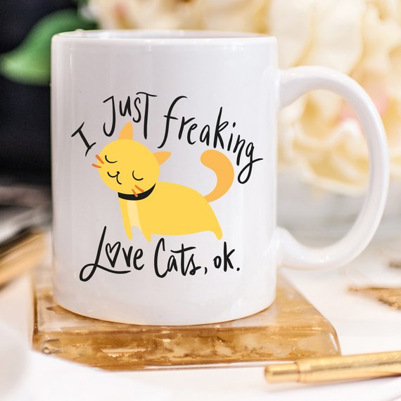 A humorous coffee mug featuring the phrase 'I Just Freaking Love Cats OK', designed for cat lovers, made from high-quality ceramic.