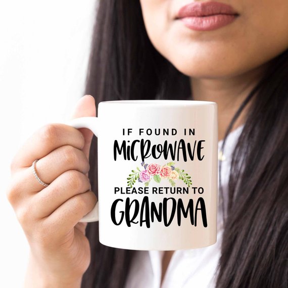 White ceramic mug with humorous text 'If Found In Microwave Please Return to Grandma' printed on both sides, ideal for coffee or tea.