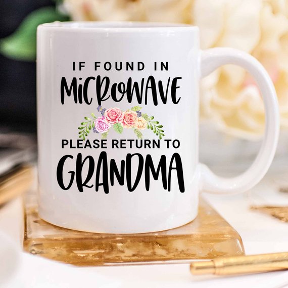 White ceramic mug with humorous text 'If Found In Microwave Please Return to Grandma' printed on both sides, ideal for coffee or tea.