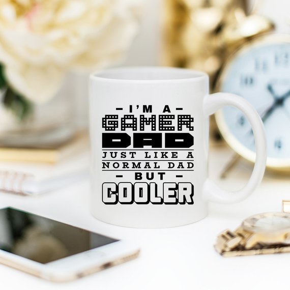 Funny coffee mug featuring the phrase 'I'm A Gamer Dad, Just Like A Normal Dad But Cooler', designed for gamer dads.