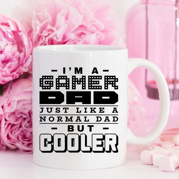 Funny coffee mug featuring the phrase 'I'm A Gamer Dad, Just Like A Normal Dad But Cooler', designed for gamer dads.