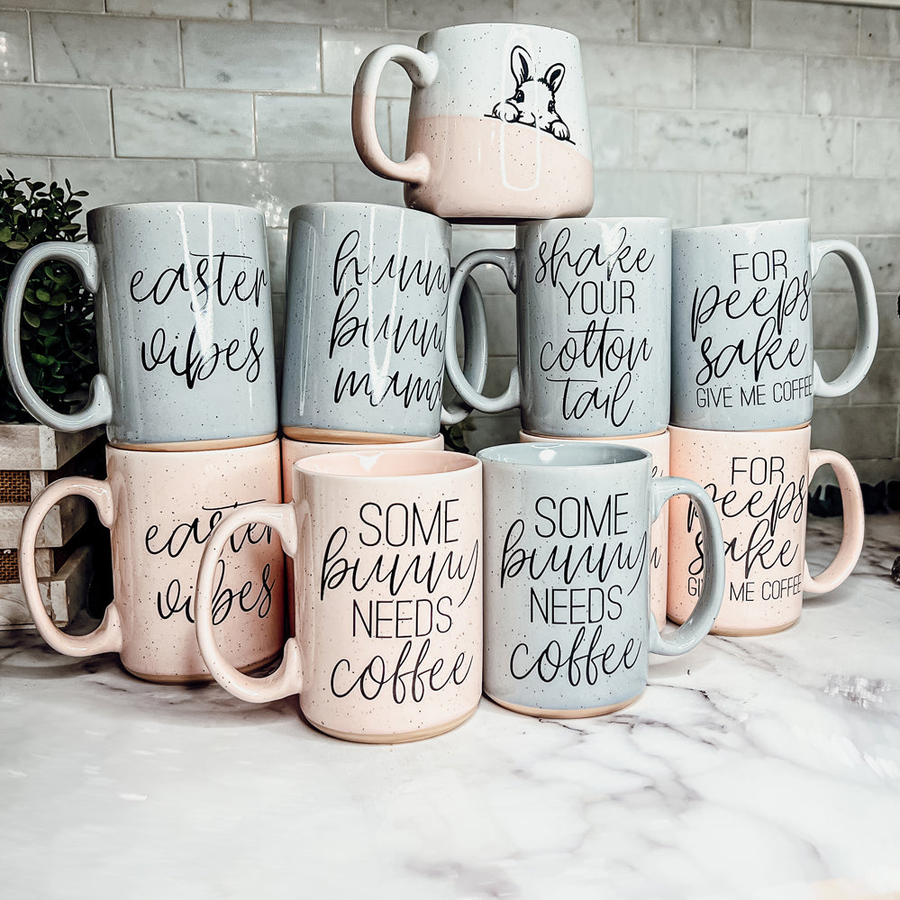 A collection of imperfect Easter mugs in pink and blue, showcasing unique designs and minor imperfections.