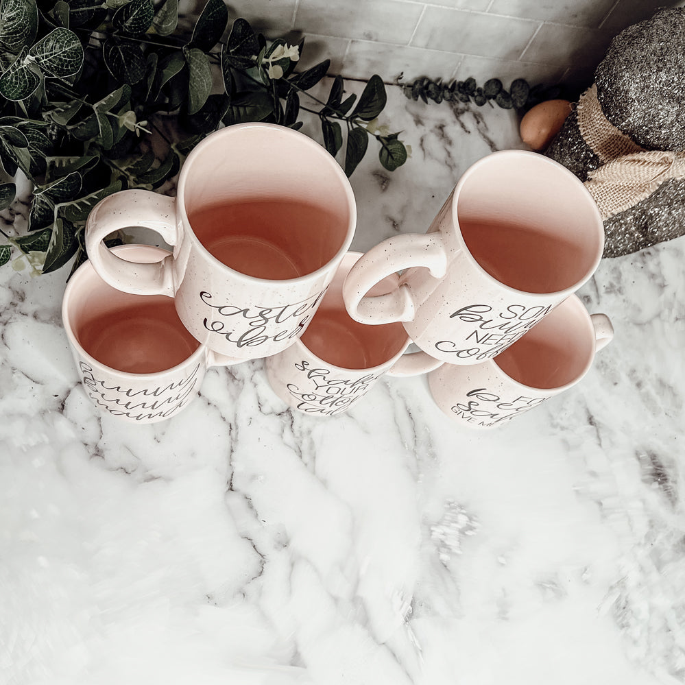 A collection of imperfect Easter mugs in pink and blue, showcasing unique designs and minor imperfections.