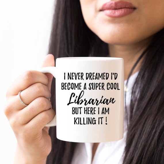 A white ceramic mug featuring a vibrant librarian-themed design on both sides, perfect for coffee or tea.