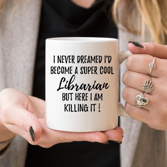 A white ceramic mug featuring a vibrant librarian-themed design on both sides, perfect for coffee or tea.