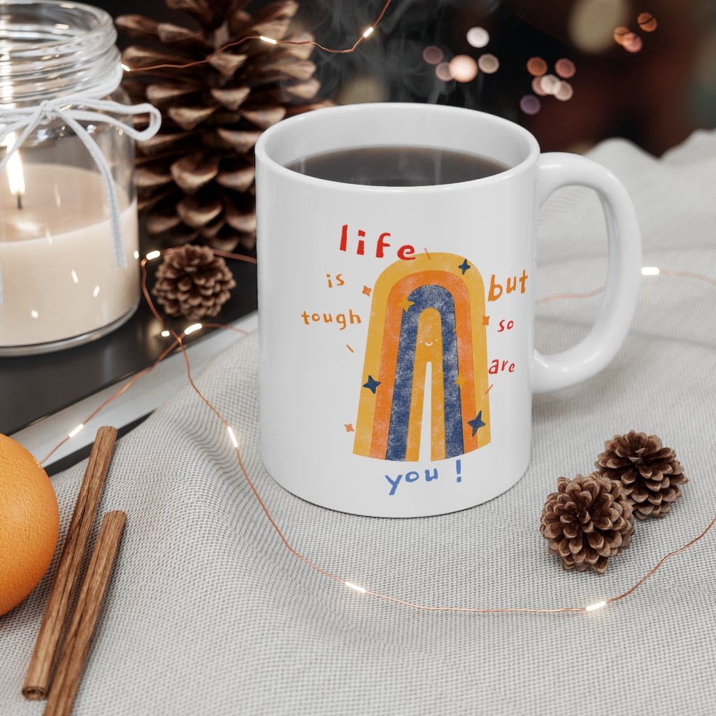 White ceramic coffee tea mug with inspirational text 'Life Is Tough, But So Are You', featuring a C-handle and rounded corners.