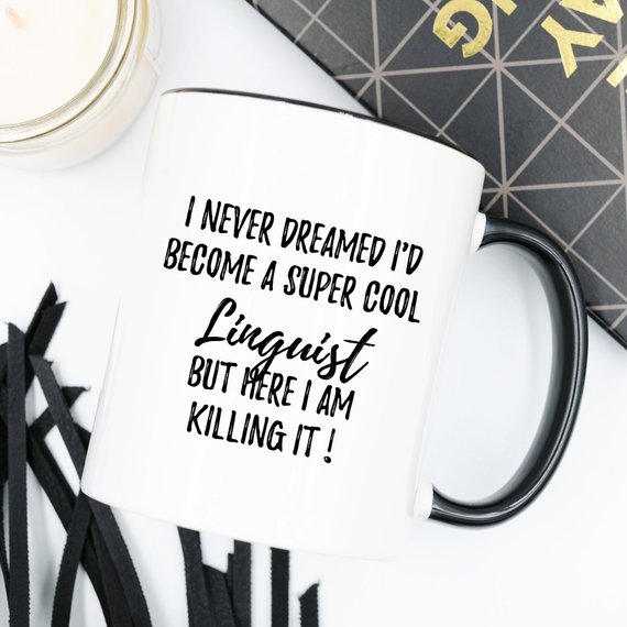 A high-quality white ceramic mug featuring a vibrant linguist-themed design printed on both sides, perfect for coffee lovers.