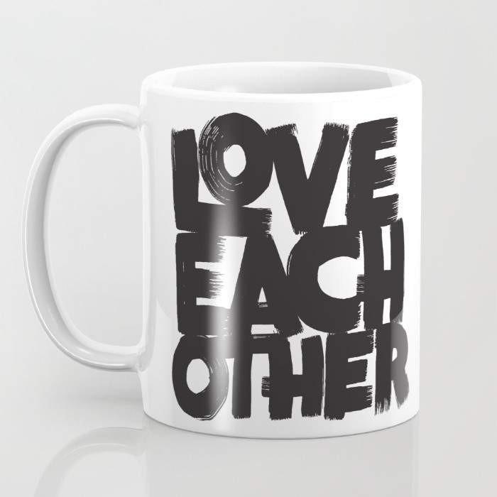 A stylish 15-ounce ceramic mug with a wrap-around design featuring the phrase 'Love Each Other', showcasing a large handle for easy gripping.