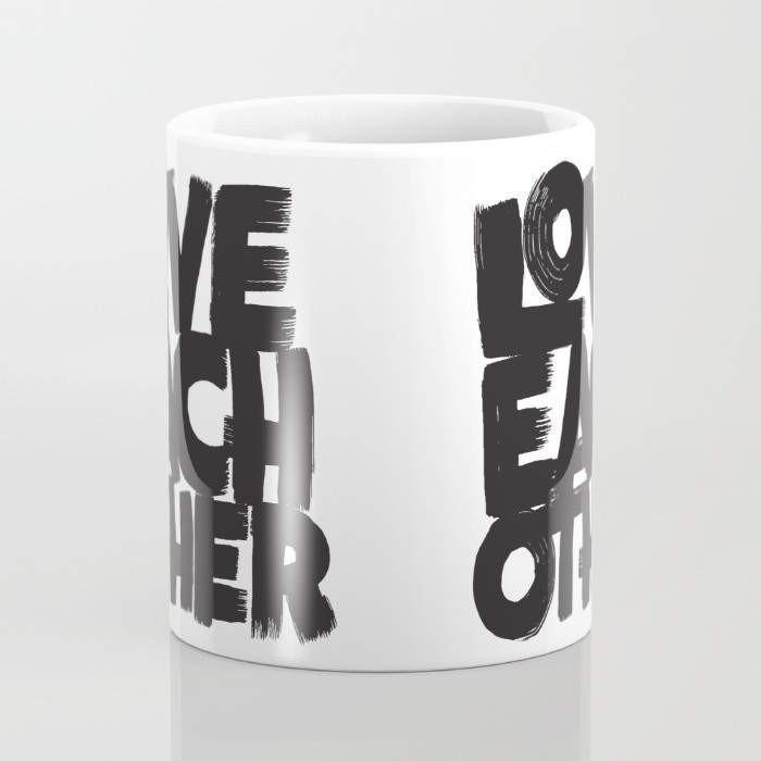 A stylish 15-ounce ceramic mug with a wrap-around design featuring the phrase 'Love Each Other', showcasing a large handle for easy gripping.