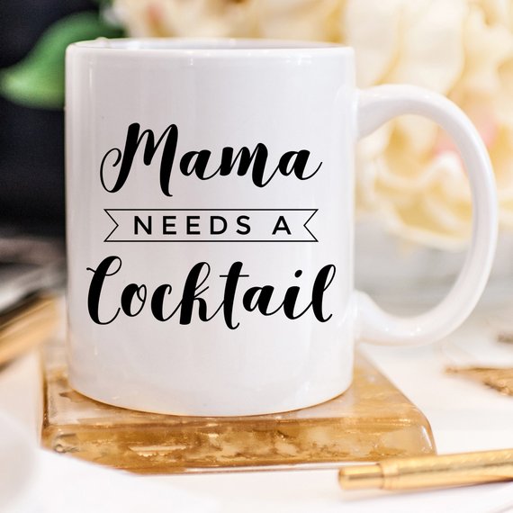 A humorous coffee mug with the text 'Mama Needs A Cocktail', showcasing a fun design perfect for Mother's Day gifts.